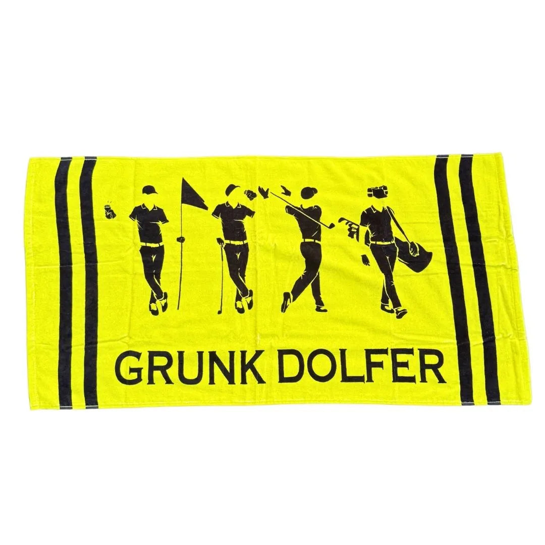 The Grunk Dolfer Premium Cotton Towel is an oversized yellow towel with black stripes, featuring four golfer silhouettes and the text “GRUNK DOLFER” at the bottom. Made from premium cotton for ultimate softness.