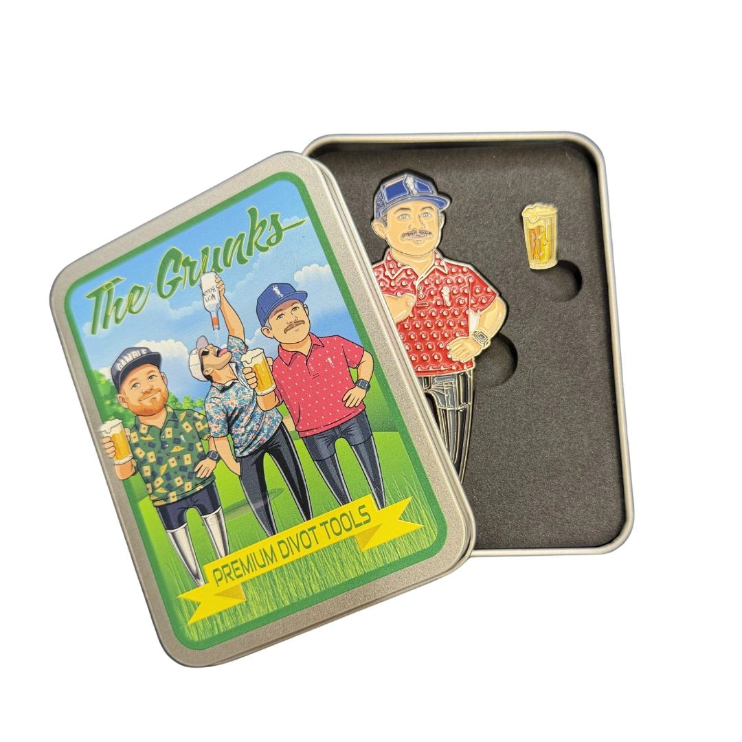 A metal tin labeled Grunk Dolfer with a cartoon of three men holding beers contains the Grunk CEO Divot Tool—a golf divot repair tool with a magnetic ball marker—set in black foam.