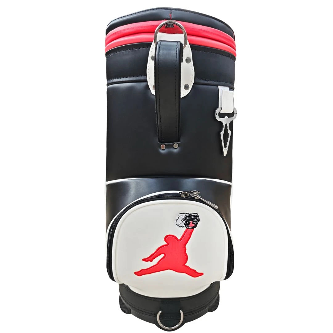 The Chunkman Den Caddy by Grunk Dolfer is a black and white premium golf bag with red accents, showcasing a red dunking basketball player silhouette on the front pocket.