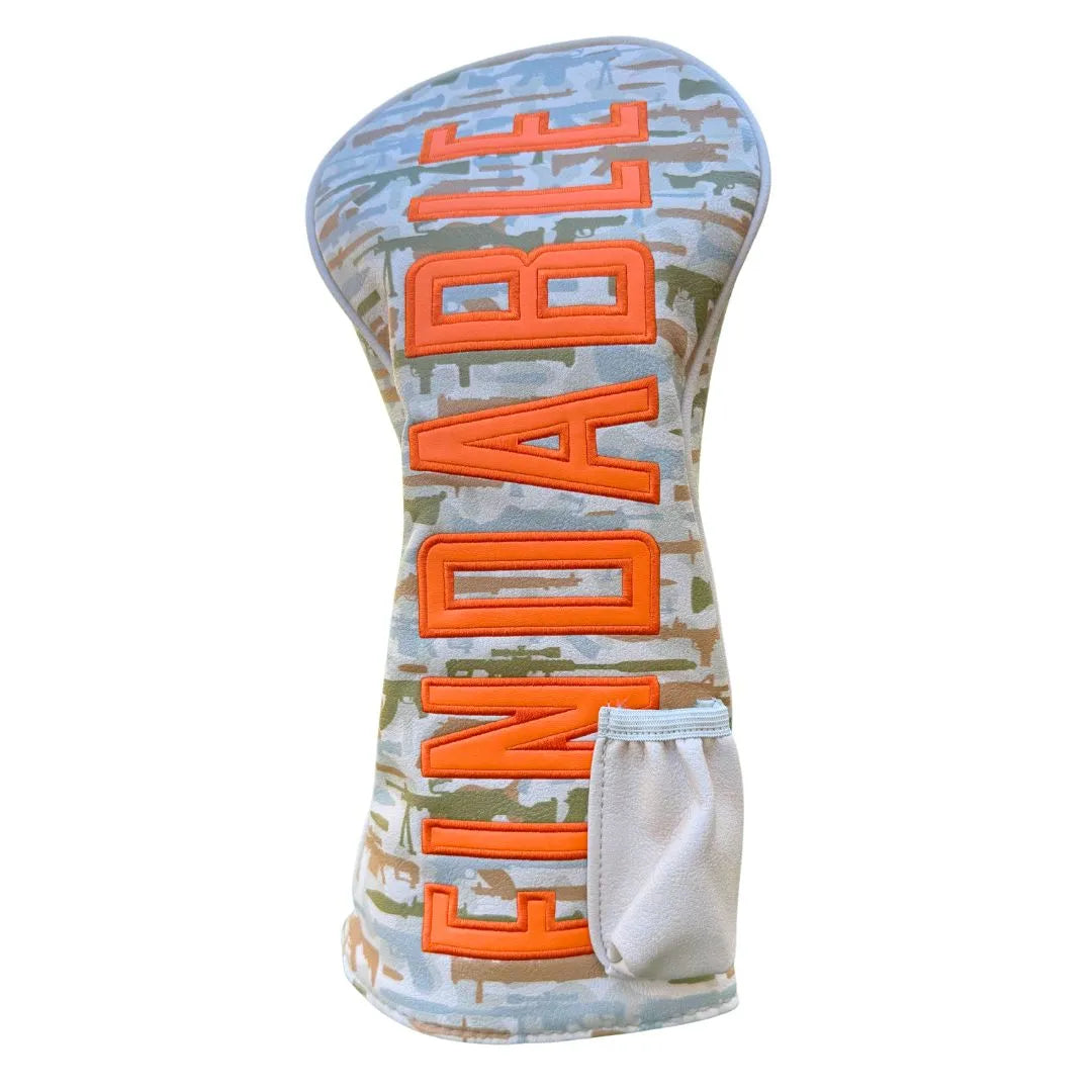 The Grunk Dolfer Findable Driver Cover features a camo design, bold orange "FINDABLE" lettering, and a handy beige side pocket for added convenience.