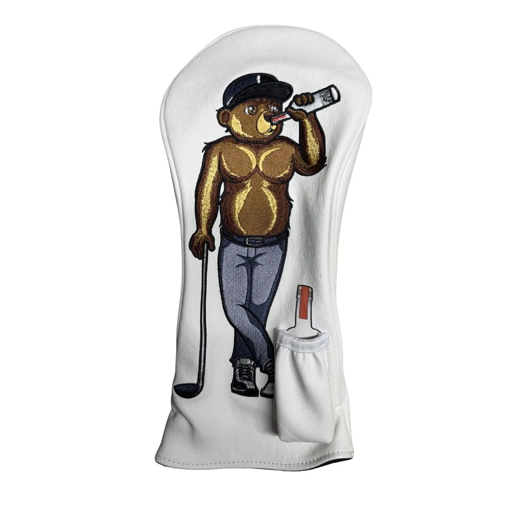 Show off your style on the course with the Grunk Dolfer Bearly Sober Driver Cover—a white headcover embroidered with a bear in a black cap and jeans, holding a golf club and sipping from a bottle, plus a handy small white pocket attached. This unique accessory is the perfect way to add personality to your golf bag.