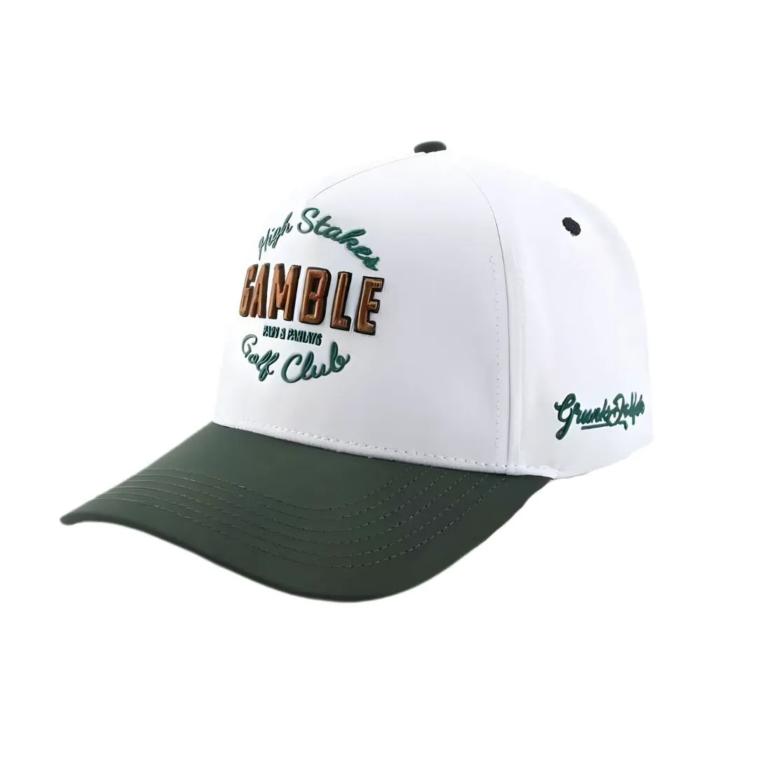 The Grunk Dolfer High Stakes GC Hat features white and dark green colors with "High Stakes Gamble Golf Club" embroidered in green and brown. It has a curved bill, ventilation holes, and is perfect for fans of Golden Tickets or the GC Sweepstakes.