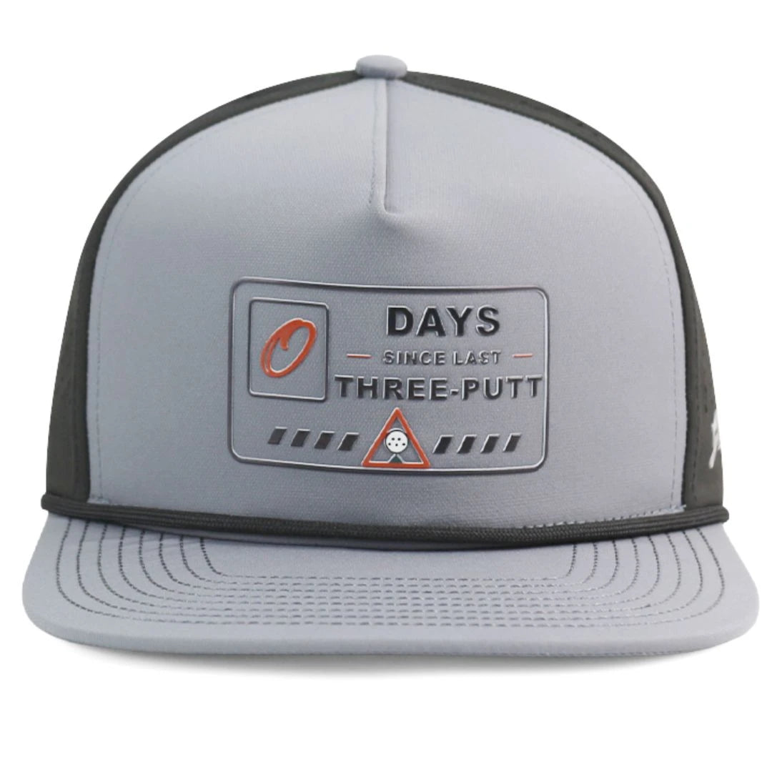 The Grunk Dolfer Workplace Hazard Hat is a gray and black cap featuring a 0 DAYS SINCE LAST THREE-PUTT patch with golf ball and red warning icon—perfect for golfers or your next office hazard.