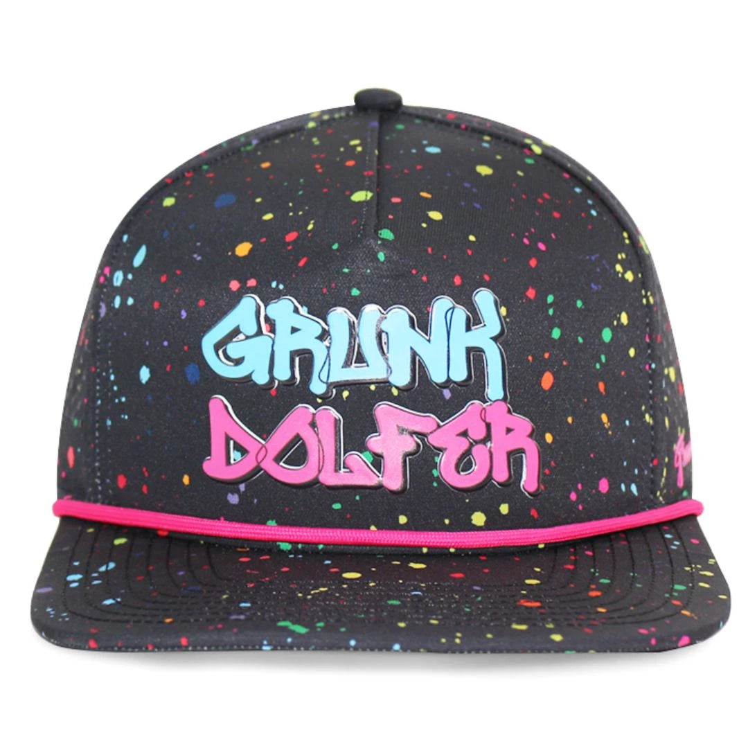 The Black Splatter Hat by Grunk Dolfer features colorful paint, blue and pink GRUNK DOLFER graffiti on the front, and a thin pink rope above the brim—a bold choice for golfers.