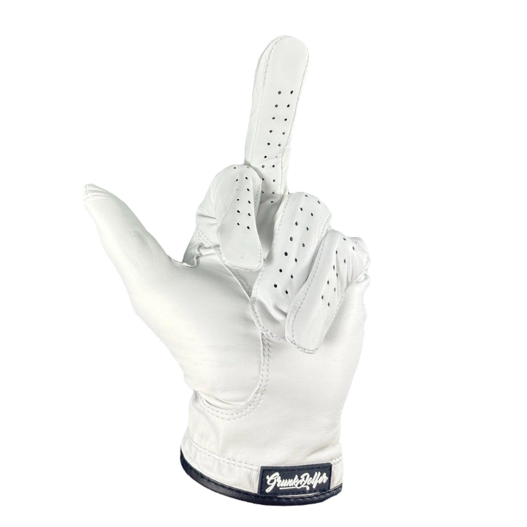 The Grunk Dolfer Grunk Glove is a white Cabretta leather golf glove with ventilation holes, shaped in an upright middle finger gesture and finished with a bold black wrist label featuring white text.