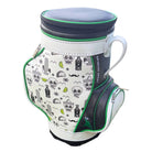The Grunk Dolfer Drinko Den Caddy is a white and black golf bag with green trim, playful skull, cactus, bottle, lime, and mustache graphics. It includes a handle, zippered compartments, and an insulated beverage cooler.
