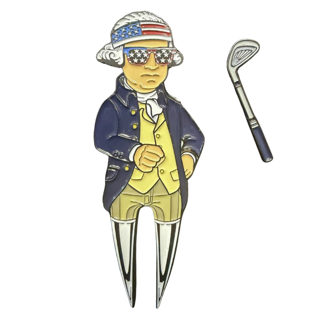 The Grunk Dolfer Washington Divot Tool features a figure in colonial attire with American flag sunglasses and headband, plus a magnetic golf club-shaped ball marker.