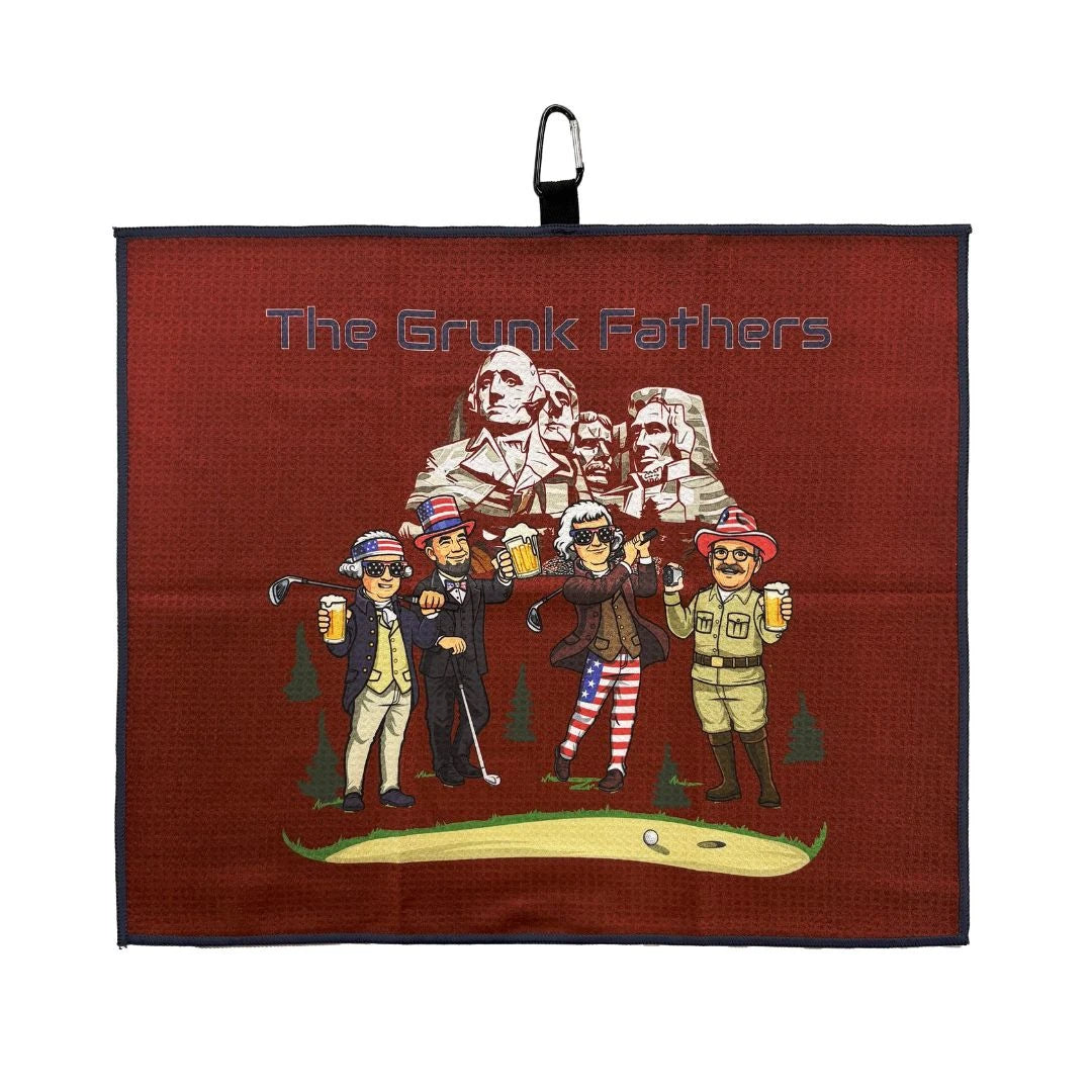 Display your passion for golf with the Grunk Dolfer Grunk Fathers Towel, showing four cartoon men in patriotic golf outfits holding drinks before Mount Rushmore—a fun, patriotic accessory for every golfer.