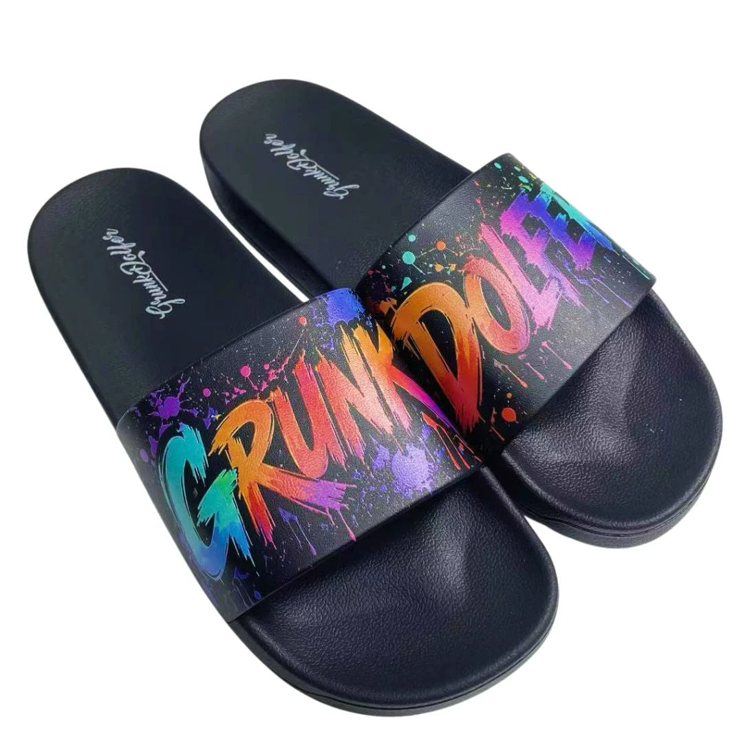 Step out in style with the Splatter Grunk Slides by Grunk Dolfer—black sandals featuring colorful paint splatters and the word GRUNKDOLF boldly displayed in multicolored letters across the straps. These waterproof sandals have an anti-slip sole, making them perfect for adding a splash of personality to any outfit, wherever you go.