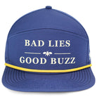 The Bad Lies Good Buzz Hat by Grunk Dolfer is a blue golf cap with white BAD LIES GOOD BUZZ text, a bee graphic, and a thin yellow band on the brim—ideal for any drinking club.