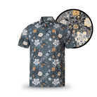 The Grunk Dolfer Harvest Fairway is a short-sleeve button-up shirt with grey, white, soft orange, and beige floral patterns on a dark background—detailed flower and leaf designs make it a perfect fall wardrobe upgrade.