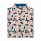 The Grunk Dolfer Desert Classic is a light-colored button-up with a desert-themed print of cacti, rocks, and small animals in blue and green—ideal for a laid-back look or golf apparel.