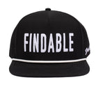The Grunk Dolfer Findable Hat is a black snapback golf hat with FINDABLE in bold white letters, a white stripe on the brim, side ventilation holes, and a built-in magnet for your ball marker.