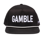 The Grunk Dolfer Grunk Gamble Hat is a black snapback featuring bold white GAMBLE embroidery on the front and a white-trimmed brim, offering breathable comfort for golf or daily wear.