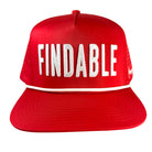 The Red Findable Hat by Grunk Dolfer features a classic trucker style in red with white embroidered FINDABLE text and a white accent stripe above the brim—ideal for the course and pairing with your favorite ball marker.
